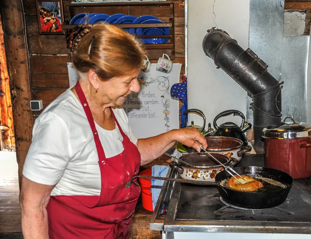 Maria Gruber beim Zubereiten von Bauernkrapfen auf der Muhreralm