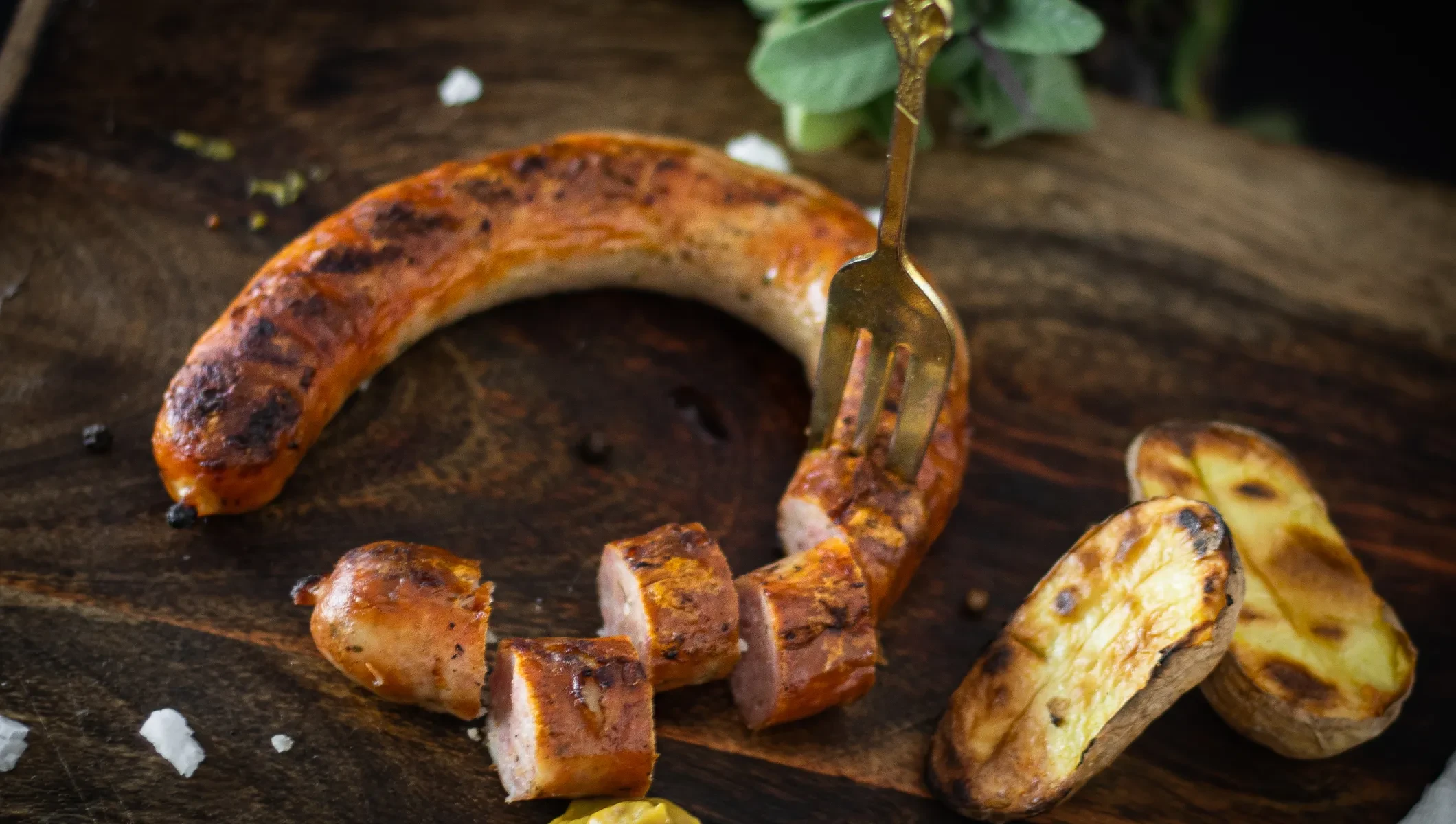 Salzburger Grillwurst Metzgerei Urban - fertig gegrillt serviert mit gegrillten Kartoffelhälften