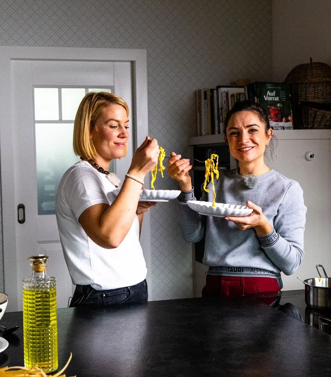 Damen mit Nudelletter in der Küche